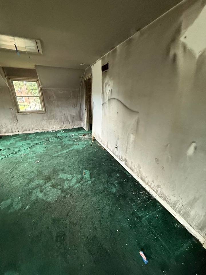 Bedroom wall blistered and darkened by smoke after a house fire